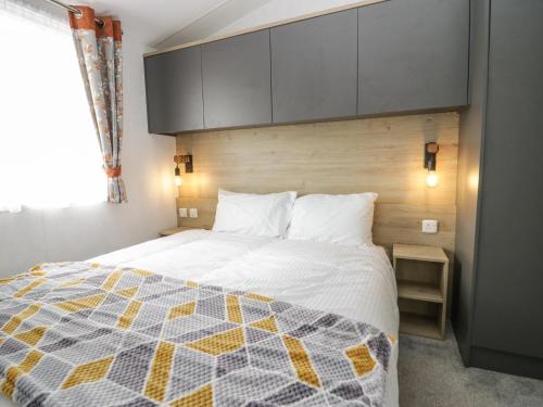 a bedroom with a bed with a quilt on it at Hazel in Denny