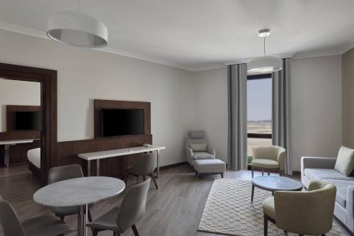 a living room with a couch and a table and chairs at Riyadh Airport Marriott Hotel in Riyadh