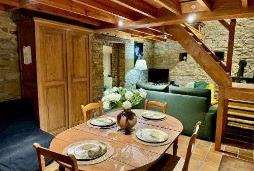 a dining room table with a vase of flowers on it at Gites Rausa in Modave