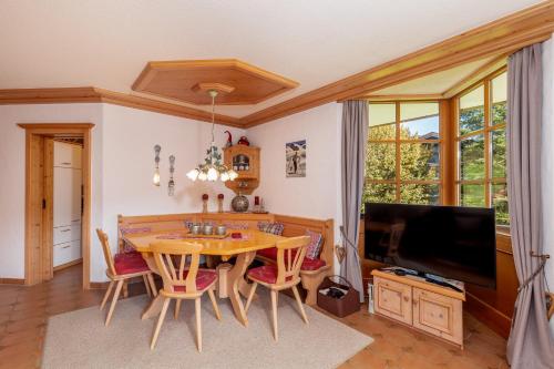a dining room with a table and chairs and a television at Ferienwohnung Elisabeth in Reit im Winkl