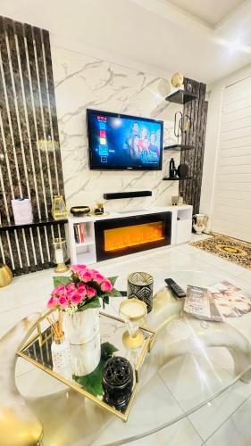 a living room with a glass table and a tv at House of Versace in Gqeberha