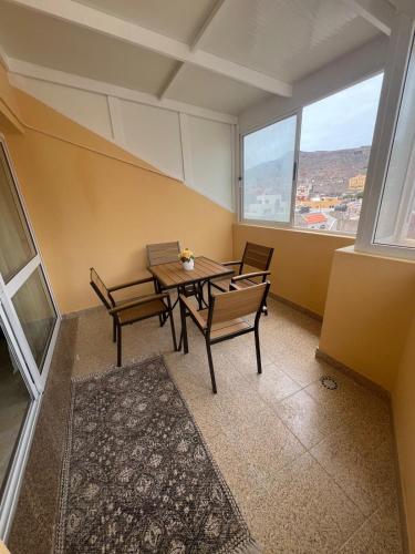 a dining room with a table and chairs and a window at Apartamento Moderno in Mindelo