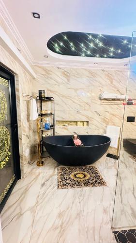 a bathroom with a black tub in a marble wall at House of Versace in Gqeberha