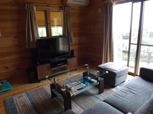 a living room with a couch and a tv at Holiday Home Fu in Nakijin
