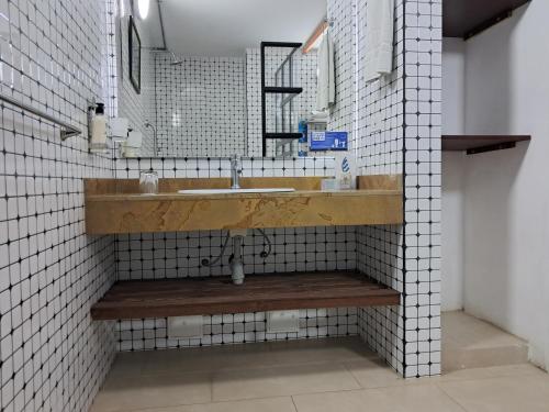 a bathroom with a sink and white tiled walls at La Floresta de Cite Hotel in Cite