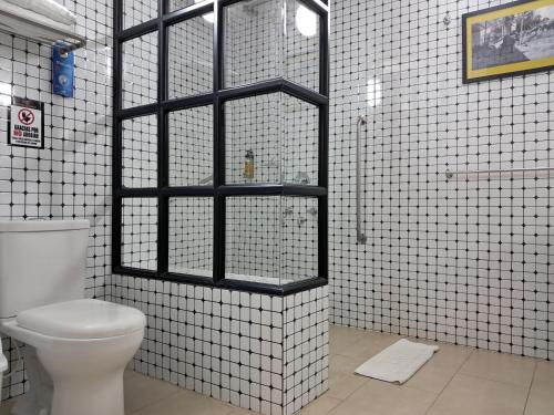 a bathroom with a toilet and a glass window at La Floresta de Cite Hotel in Cite