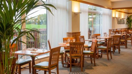 a restaurant with wooden tables and chairs and windows at Holiday Inn Washington by IHG in Washington