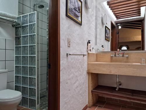 a bathroom with a sink and a toilet at La Floresta de Cite Hotel in Cite