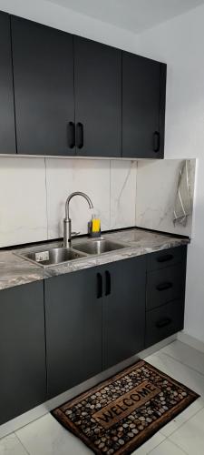 a kitchen with a sink and a rug on the floor at Park Apartment in Xanthi
