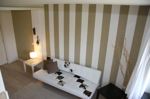 a living room with a white couch and striped wall at Hotel Borgo Pantano in Siracusa