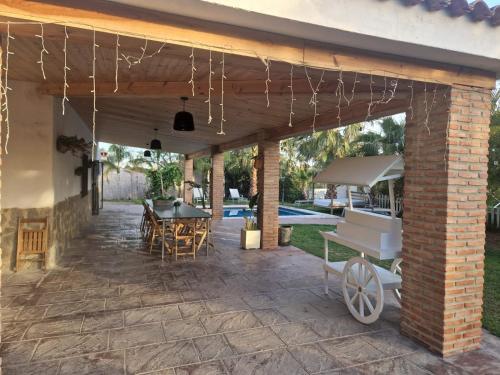 a patio with a table and chairs and a grill at Villas de encanto in Vilamarxant