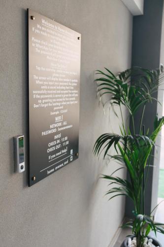 a menu sign on a wall with a plant at Home Avenue in Alexandroupoli
