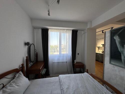 a bedroom with a bed and a window at Superb loft Tashkent downtown in Tashkent