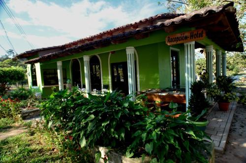 a small green house with a sign on it at Hotel de Campo Villa de Ada in Gracias