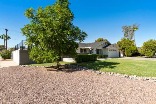 a house with a tree in the front yard at Heated pool, Sports Court, Pool table, King beds in Tempe Junction