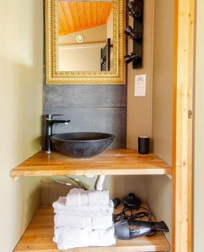 une salle de bain avec un lavabo, un miroir et des serviettes dans l'établissement Chalet Mer et Pins, à Agde