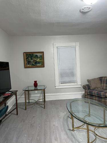 a living room with a couch and a glass table at The Yellow-Shuttered House apt B in Sharon