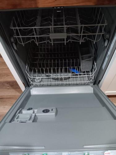 an empty dish rack in an open dishwasher at Mins to Downtown - Huntsville Oasis in Huntsville
