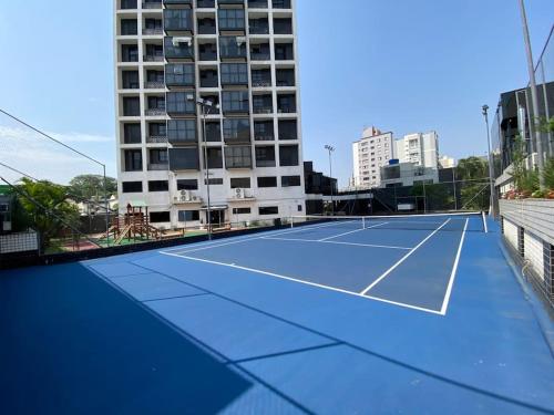 a tennis court in front of a tall building at Flat club perto metrô Santana in Sao Paulo