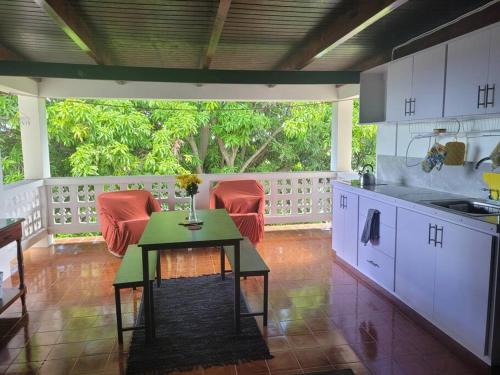 基督教堂市Graeme Hall Park Apartment的门廊上摆着厨房、桌子和红色椅子。