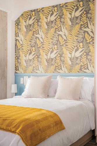 a bedroom with a large bed with a yellow blanket at 5Q House Quinta Camacho in Bogotá