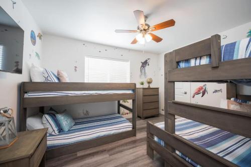 two bunk beds in a room with a ceiling fan at Sleeps 22 Two Houses Game Rooms in Oceano
