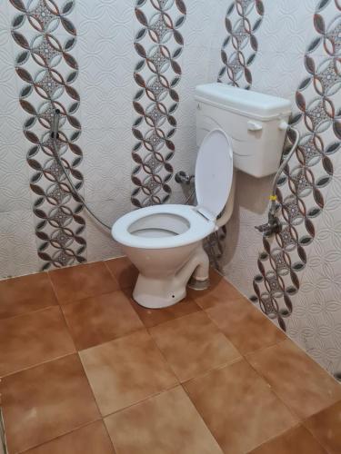a bathroom with a white toilet in a room at Mild Life Hostel Rishikesh in Rishīkesh
