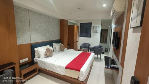 a hotel room with a bed and a television at Hotel Ranjeet Akola in Akola