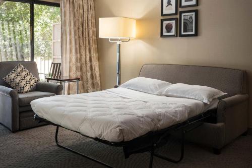 a bedroom with a bed and a chair and a window at Sheraton Palo Alto Hotel in Palo Alto