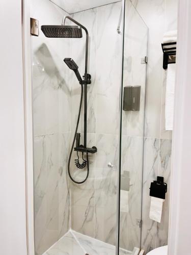 a shower with a glass door in a bathroom at Апартамент в центре Арбата in Shymkent