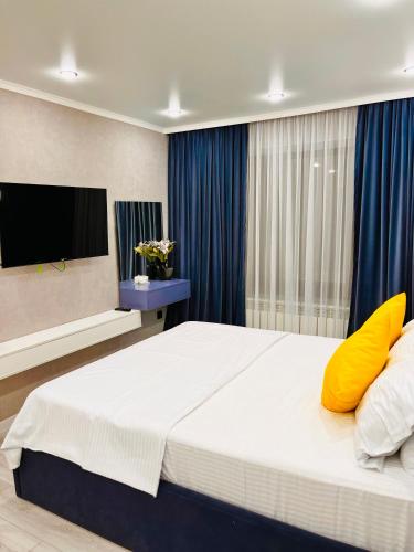 a bedroom with a large bed with yellow pillows at Апартамент в центре Арбата in Shymkent