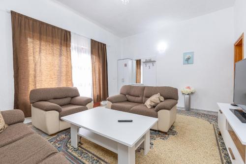 Una sala de estar con un sofá y dos sillas y una mesa. en Apartment Merak, en Sarajevo