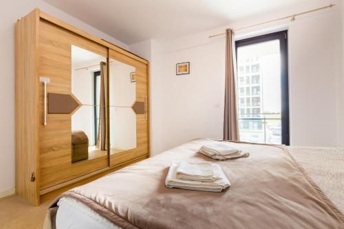 ein Schlafzimmer mit einem Bett mit Spiegel und Fenster in der Unterkunft ATENEO - TREVI 2 Rooms, Modern Apartment DeLuxe, BIG Terrace, Plus FREE Parking in Timişoara