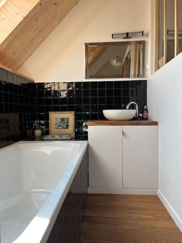 une salle de bain avec un lavabo et une baignoire dans l'établissement Charmant Cottage d'artistes, à Blainville-sur-Mer