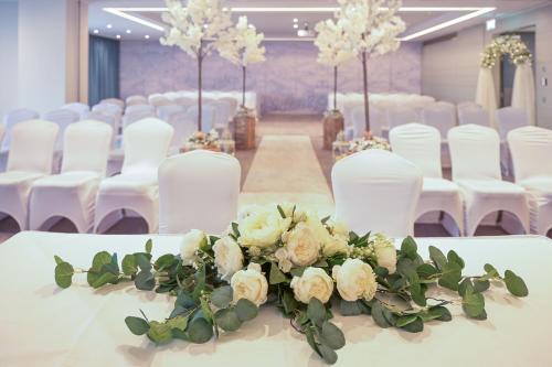 a room with white chairs and a table with flowers at Sheraton Athlone Hotel in Athlone