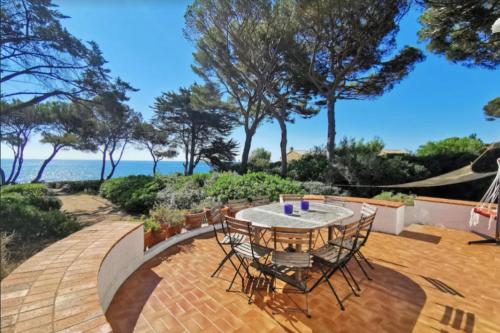 un patio avec une table et des chaises et l'océan dans l'établissement Beautiful villa with garden and sea view, à Saint-Aygulf
