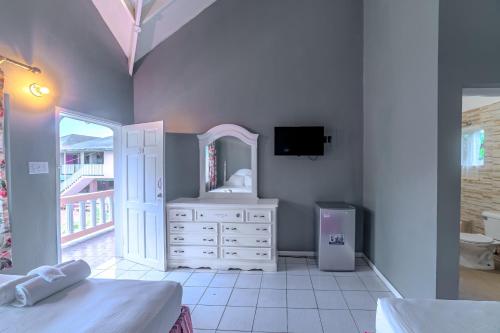 a bedroom with a white dresser and a mirror at Tamboo Resort in Negril