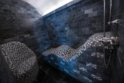 a bathroom with two chairs in a brick wall at Domaine du Haut Jardin Hôtel & Chalets Spa Privé in Rehaupal