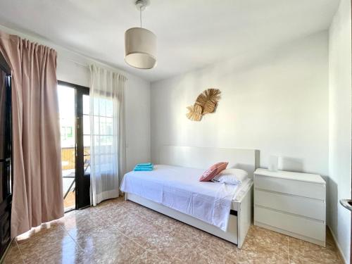 een slaapkamer met een bed met een vlinder aan de muur bij Encanto del mar, shared pool in Puerto del Carmen