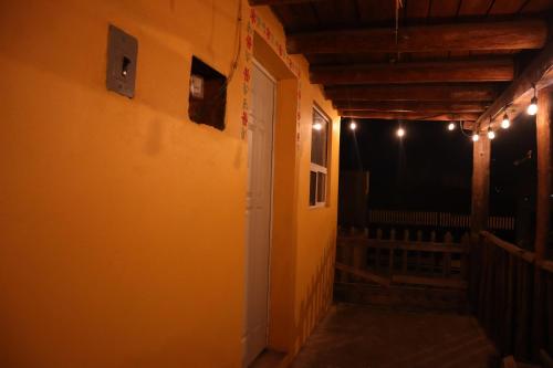 a hallway with an open door with lights on it at La Casona de los Abuelos in Creel