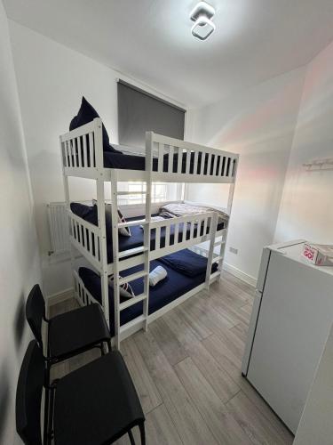 a bedroom with two bunk beds and a chair at Willesden Green Budget Guesthouse in London