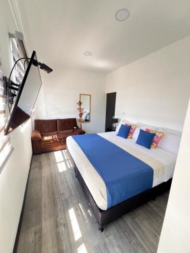 a bedroom with a large bed with blue pillows at El Solar Casa Hotel in Manizales