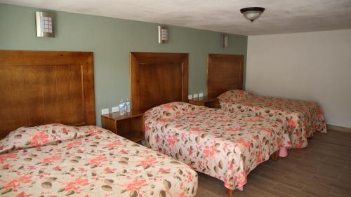 a hotel room with two beds and wooden headboards at La Casona de los Abuelos in Creel
