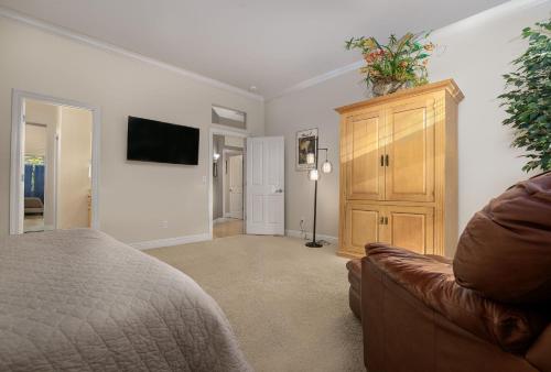 a bedroom with a bed and a couch and a tv at Cozy foothills home in Grass Valley
