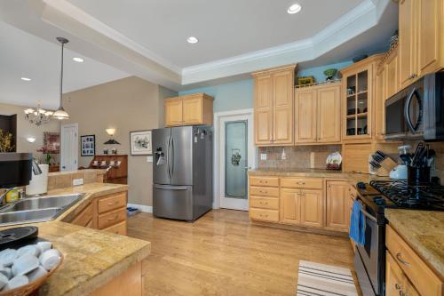 a kitchen with wooden cabinets and a stainless steel refrigerator at Cozy foothills home in Grass Valley
