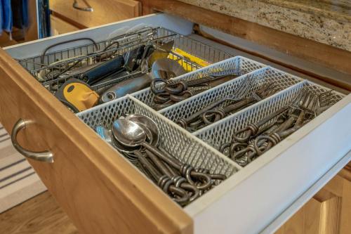 a drawer filled with dishes and utensils in a kitchen at Cozy foothills home in Grass Valley