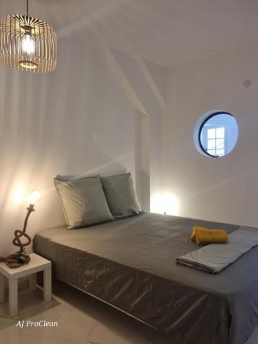 - une chambre avec un lit et une fenêtre ronde dans l'établissement Loft Les Cigales, refait à neuf à 5min de la mer avec parking - By AURAconciergerie, à Saint-Cyr-sur-Mer