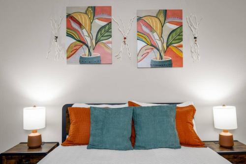 a bedroom with a bed with three paintings on the wall at Roomy Getaway! Elevate Your Stay 6 Mins to RIC! in Sandston