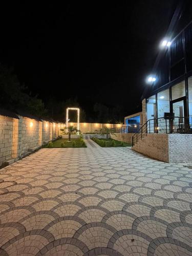 a cobblestone walkway in front of a building at night at Qafqaz Mountain Terrace İndoor Hot Pool in Gabala