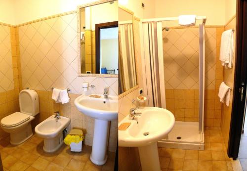 y baño con aseo, lavabo y ducha. en B&B Miramare, en Giardini Naxos